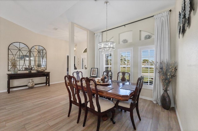 dining space featuring light hardwood / wood-style floors and an inviting chandelier