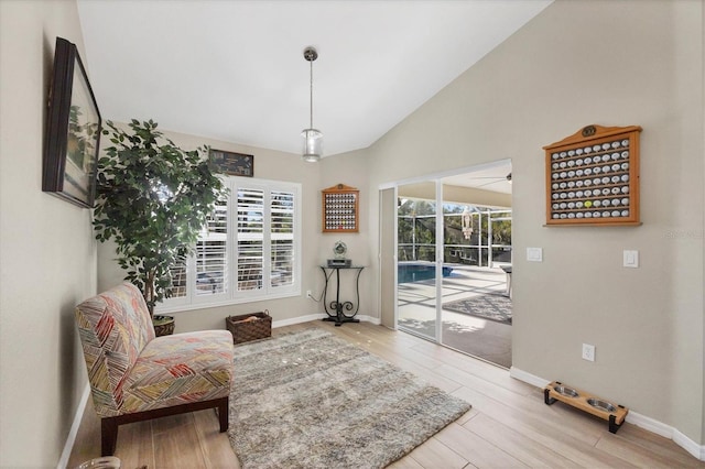 sitting room with light wood-type flooring and lofted ceiling