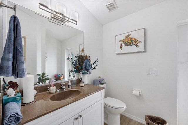 bathroom with wood-type flooring, toilet, and vanity