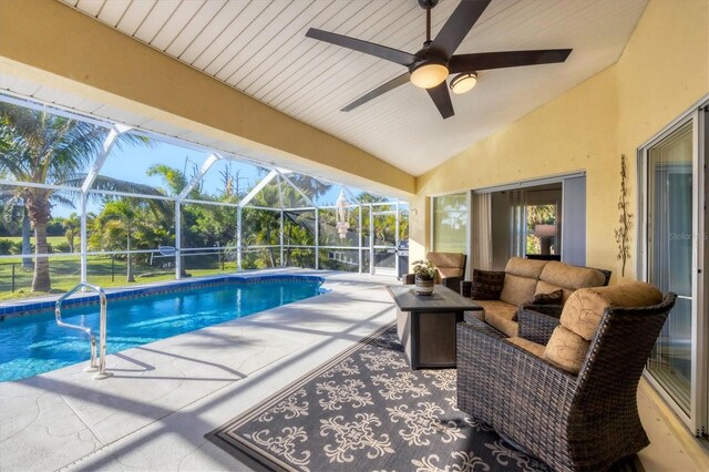 view of swimming pool featuring ceiling fan, a patio, a lanai, and an outdoor hangout area