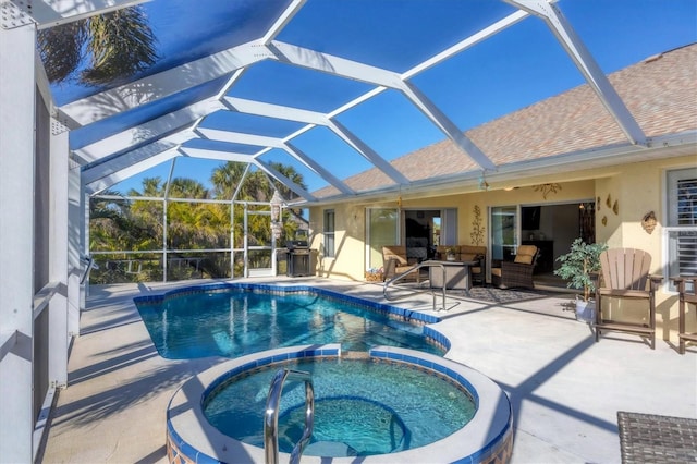 view of swimming pool featuring an in ground hot tub, a patio area, and a lanai