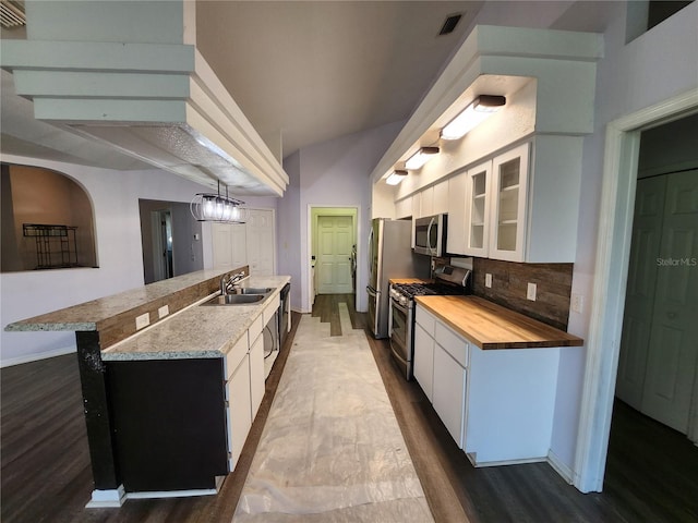 kitchen featuring sink, appliances with stainless steel finishes, tasteful backsplash, white cabinetry, and wood-type flooring