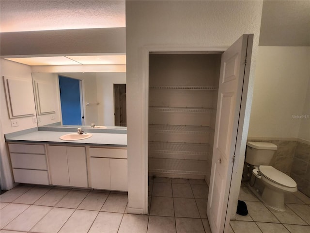 bathroom featuring tile patterned flooring, vanity, a textured ceiling, and toilet