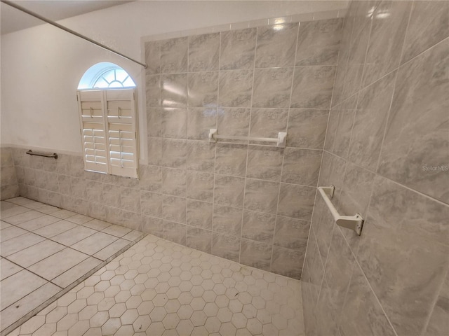 bathroom with tile patterned flooring and tiled shower