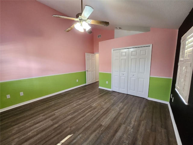 unfurnished bedroom featuring a closet, ceiling fan, lofted ceiling, and dark hardwood / wood-style floors