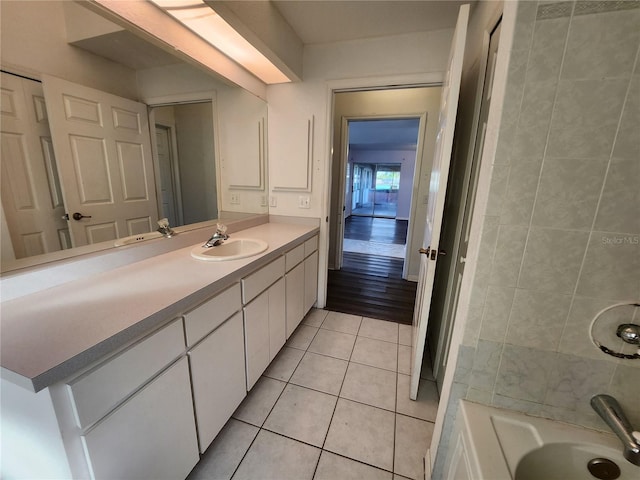 bathroom with tile patterned floors, a tub, and vanity