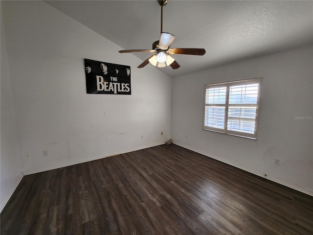 empty room with a textured ceiling, ceiling fan, dark wood-type flooring, and vaulted ceiling