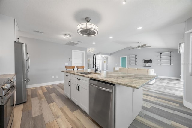 kitchen featuring stainless steel appliances, white cabinetry, a kitchen island with sink, and sink