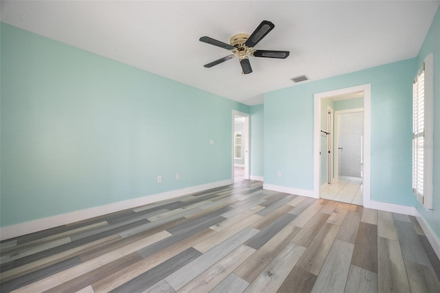 unfurnished bedroom with ensuite bath, ceiling fan, and light hardwood / wood-style flooring