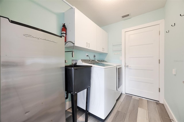 laundry area with washer and clothes dryer and cabinets