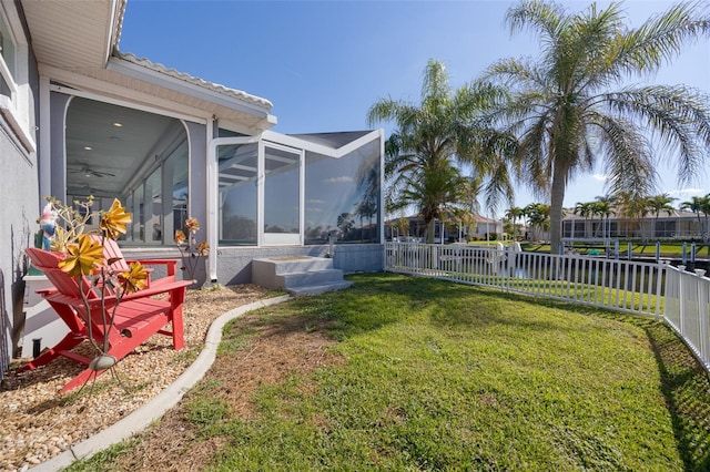 view of yard featuring a water view and a sunroom