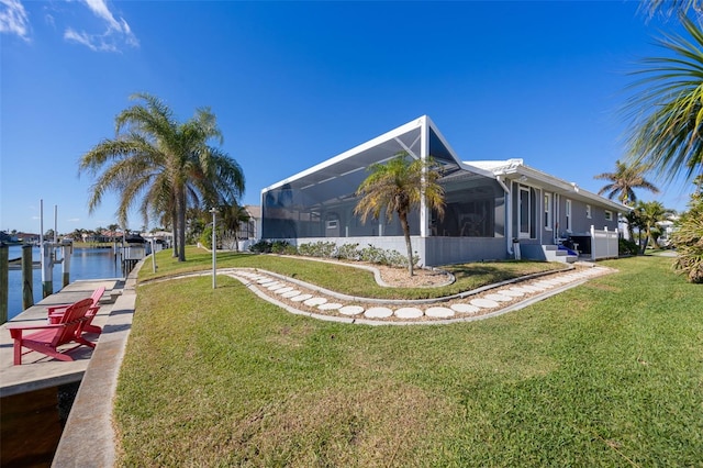 view of yard featuring glass enclosure, a dock, and a water view