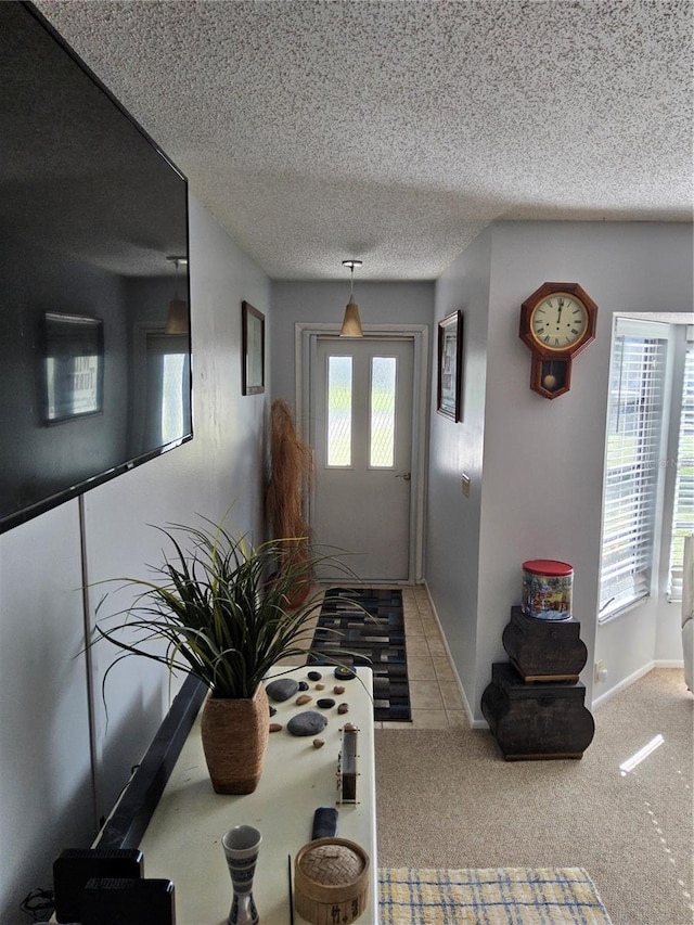 entryway with a textured ceiling and light colored carpet