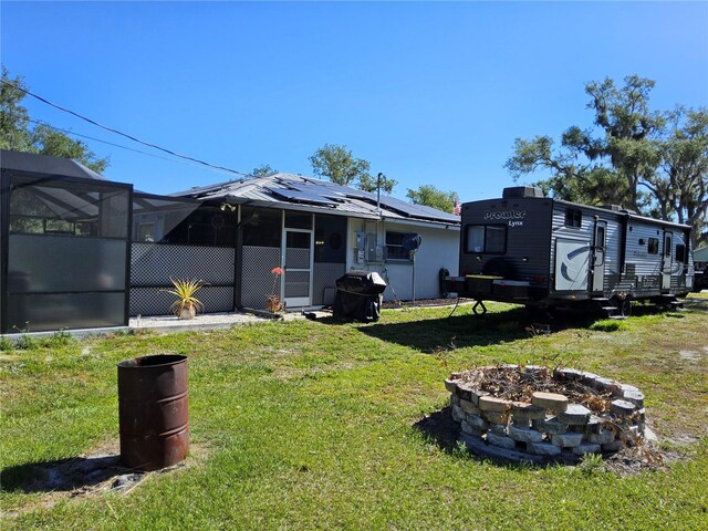 view of yard with glass enclosure and a fire pit