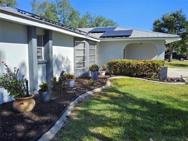 exterior space featuring a yard and solar panels