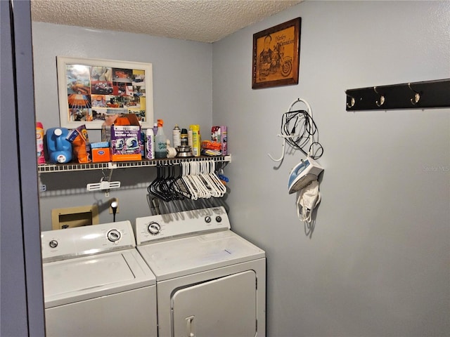 washroom with washer and clothes dryer and a textured ceiling