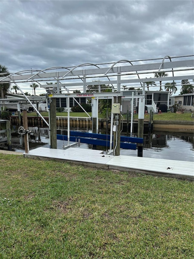 dock area featuring a water view and a lawn