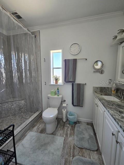 bathroom featuring hardwood / wood-style floors, toilet, curtained shower, and ornamental molding