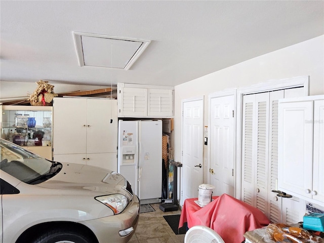 garage featuring white fridge with ice dispenser and washer / dryer