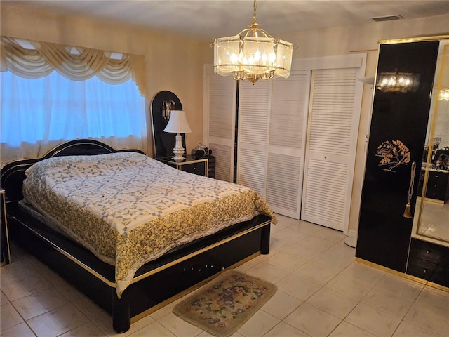 bedroom with light tile patterned floors and a notable chandelier