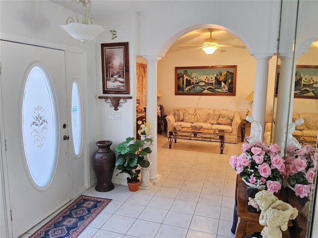 foyer entrance featuring decorative columns, ceiling fan, and light tile patterned floors