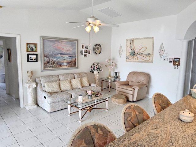 living room with ceiling fan, light tile patterned flooring, and ornate columns