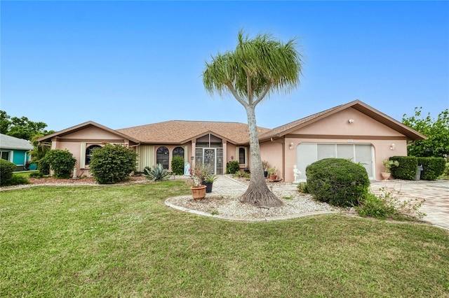 single story home with an attached garage, driveway, a front lawn, and stucco siding