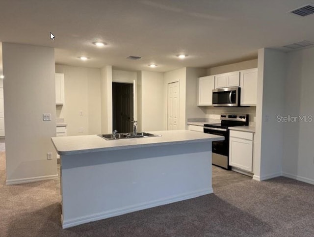 kitchen with carpet flooring, stainless steel appliances, a kitchen island with sink, sink, and white cabinets