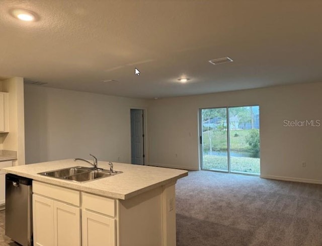 kitchen featuring white cabinetry, sink, stainless steel dishwasher, carpet floors, and a center island with sink