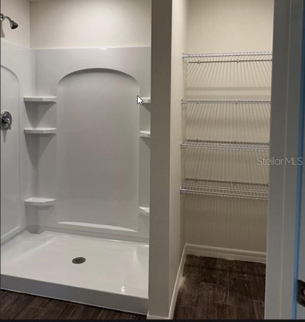 bathroom with wood-type flooring and walk in shower