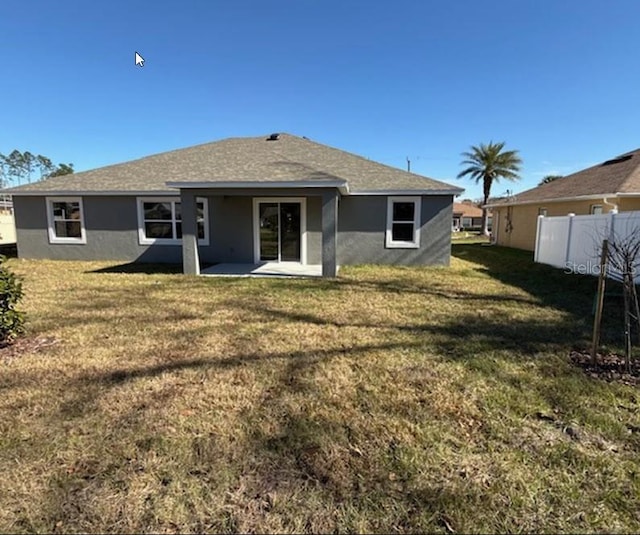 back of house with a yard and a patio