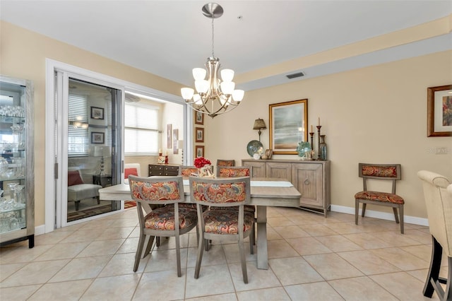 tiled dining room with a notable chandelier