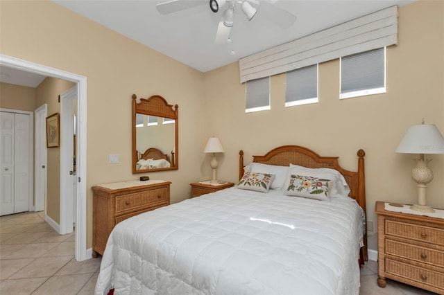 bedroom featuring ceiling fan, light tile patterned floors, and a closet