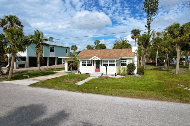 view of front of property featuring a front yard and a carport