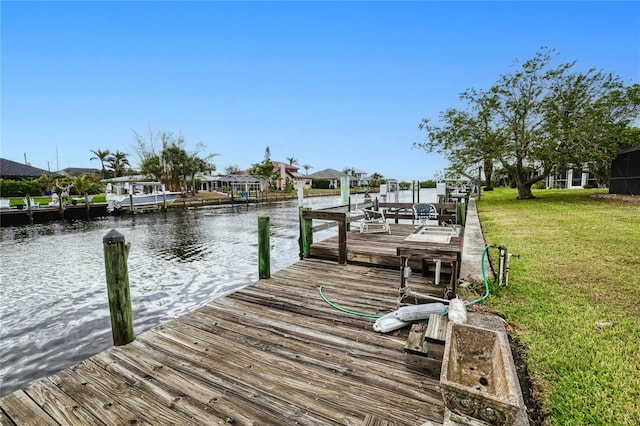 dock area with a water view and a yard