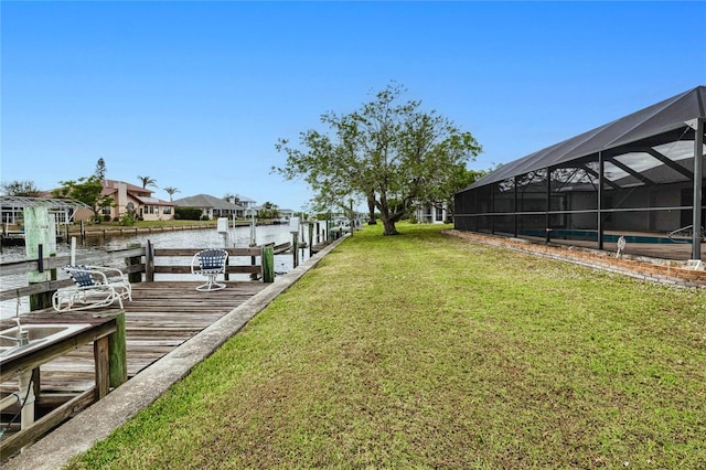 view of dock with a lanai, a yard, and a water view