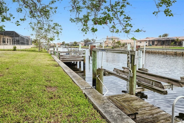 view of dock with a water view and a lawn