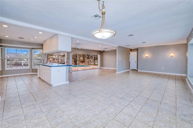 kitchen featuring ceiling fan, sink, light tile patterned floors, white cabinetry, and hanging light fixtures