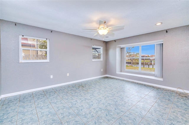 unfurnished room featuring a textured ceiling, ceiling fan, and a healthy amount of sunlight