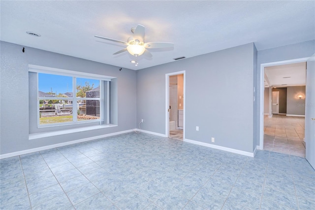 tiled empty room featuring a textured ceiling and ceiling fan