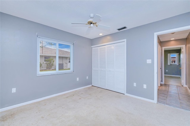 unfurnished bedroom with ceiling fan, a closet, and light carpet