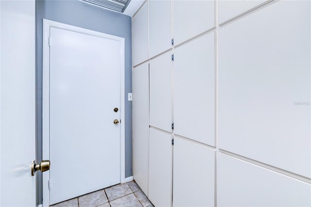 doorway to outside with light tile patterned flooring