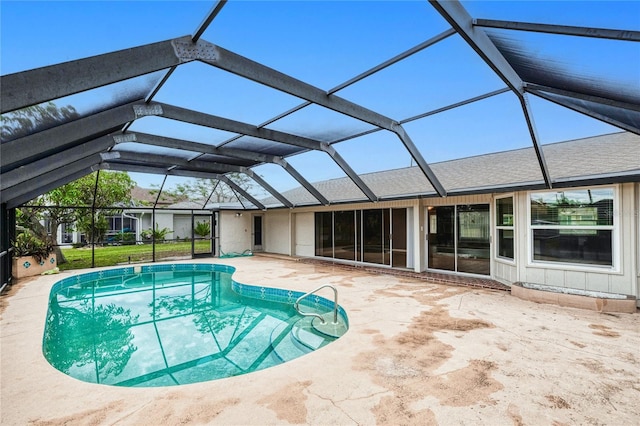 view of swimming pool featuring glass enclosure and a patio area