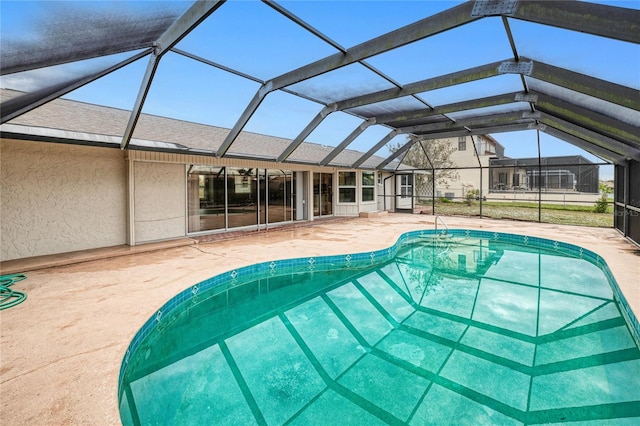 view of swimming pool with glass enclosure and a patio area