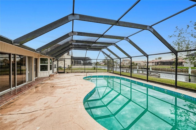 view of pool with glass enclosure, a patio area, and a water view