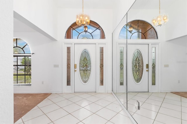 entrance foyer with light tile patterned flooring, a high ceiling, and a chandelier