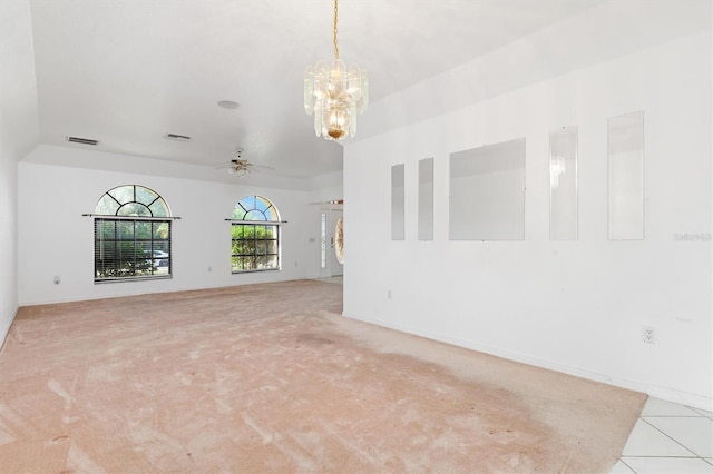 tiled empty room featuring ceiling fan with notable chandelier