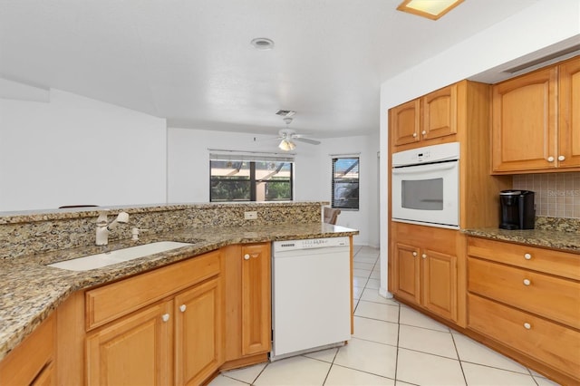 kitchen with ceiling fan, light stone countertops, white appliances, and sink