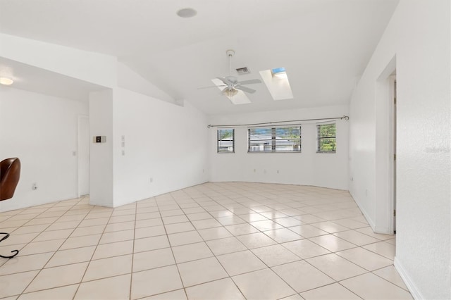 tiled spare room with ceiling fan and vaulted ceiling with skylight