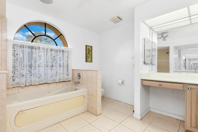 bathroom featuring vanity, a bath, tile patterned flooring, ceiling fan, and toilet